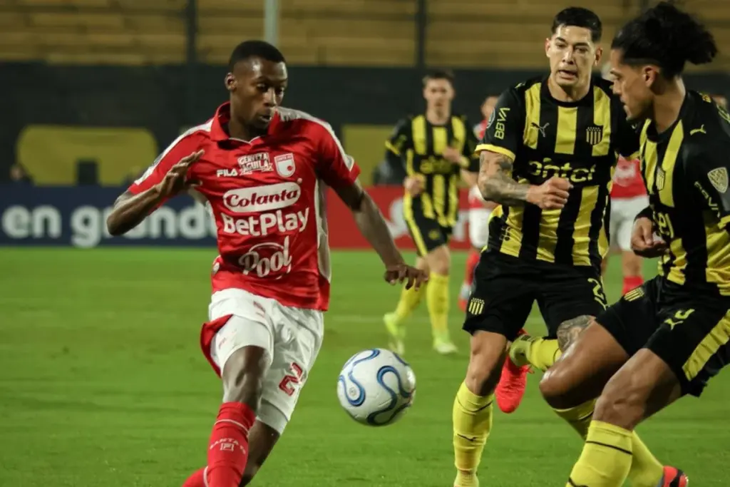 Independiente Santa Fe venció 0-1 a Peñarol en Montevideo con gol de Alexis Zapata y gran actuación de Mosquera Marmolejo. Pese al triunfo, el León jugará los playoffs de la Copa Sudamericana - Foto: @SantaFe