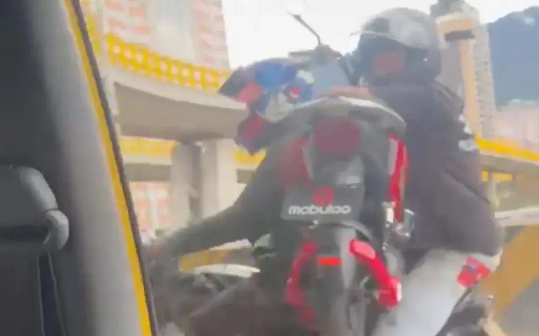 Un video viral que muestra a dos personas transportando una motocicleta sobre otra en una avenida de Bogotá ha desatado indignación - Foto: Captura de video