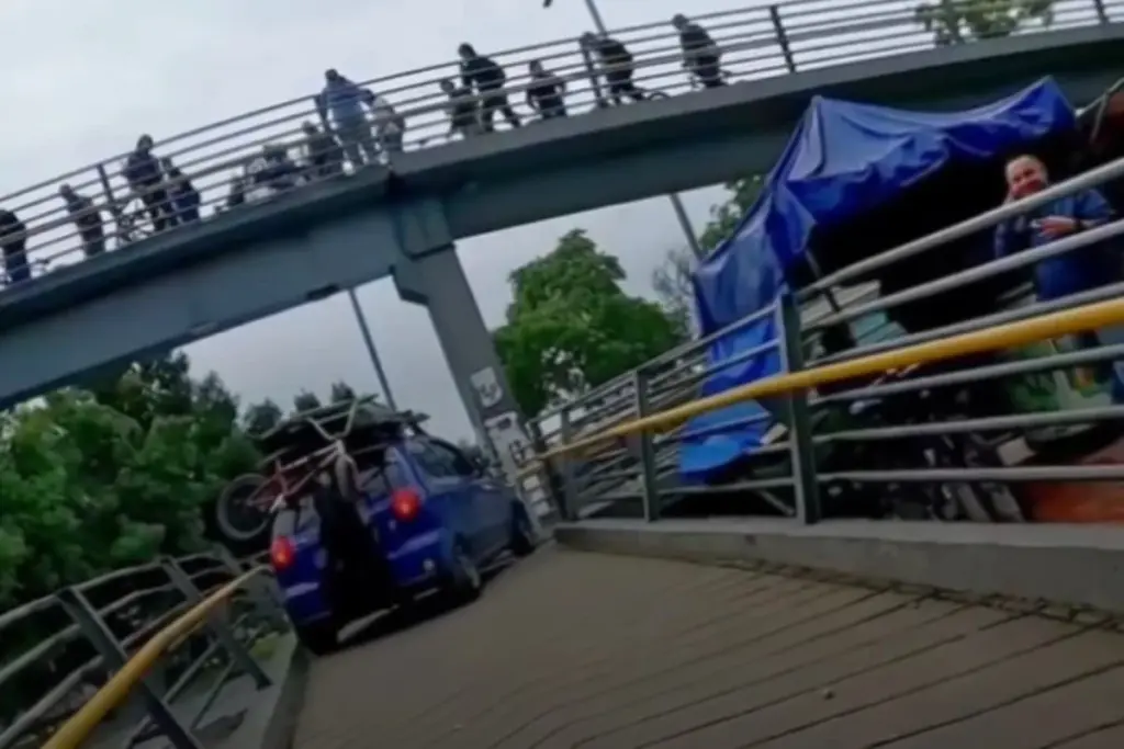 El conductor del Chevrolet Spark azul reincide al intentar subir su vehículo a un puente peatonal en Bogotá para redes sociales - Foto: Captura de video