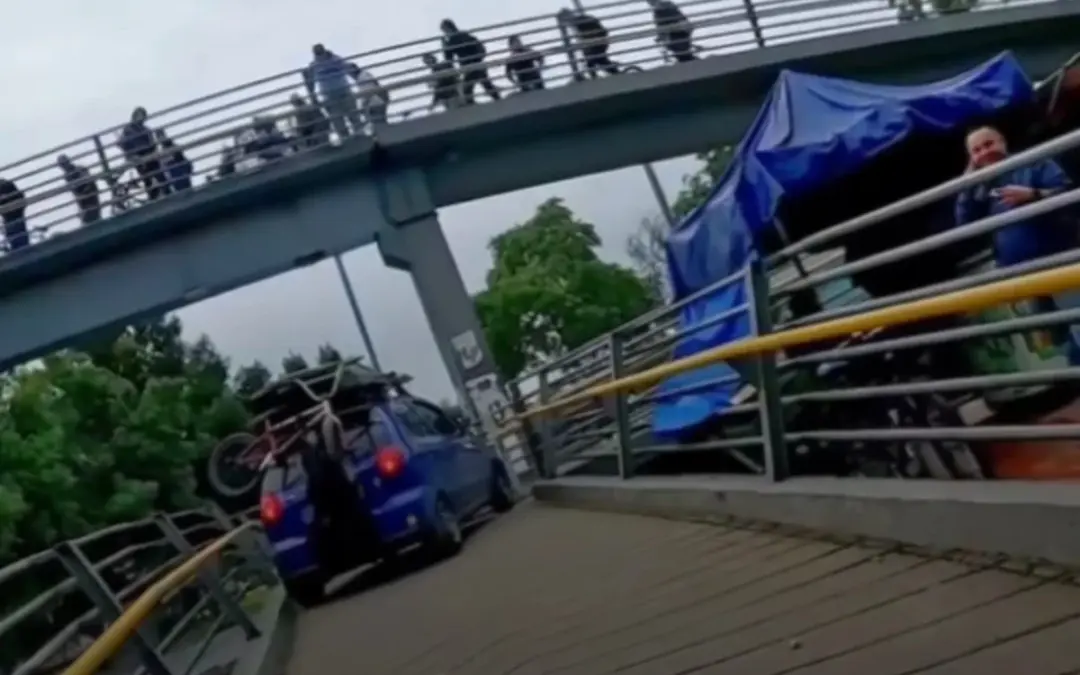 El conductor del Chevrolet Spark azul reincide al intentar subir su vehículo a un puente peatonal en Bogotá para redes sociales - Foto: Captura de video